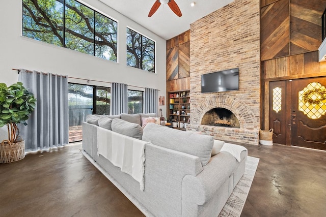 702 California Blvd Unit 702, New Braunfels, TX 78130 - living area with a towering ceiling, concrete floors, a ceiling fan, and a brick fireplace