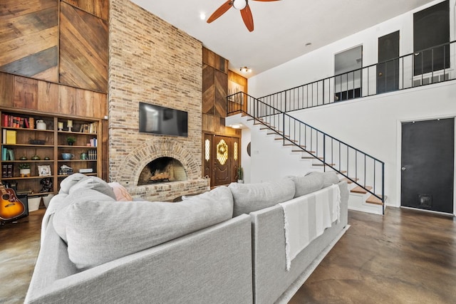 702 California Blvd Unit 702, New Braunfels, TX 78130 - living room with concrete flooring, a towering ceiling, ceiling fan, stairway, and a brick fireplace
