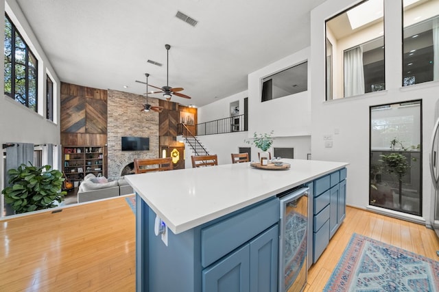 702 California Blvd Unit 702, New Braunfels, TX 78130 - kitchen with beverage cooler, blue cabinetry, a ceiling fan, and a fireplace