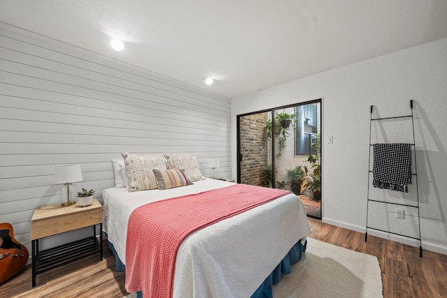 702 California Blvd Unit 702, New Braunfels, TX 78130 - bedroom with access to outside, wood finished floors, and wooden walls