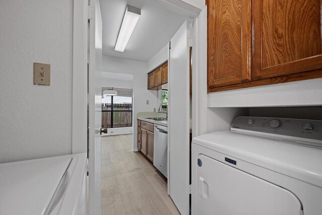 3801 Menchaca Rd Unit 6, Austin, TX 78704 - laundry area featuring washer / clothes dryer, cabinet space, and light wood-type flooring