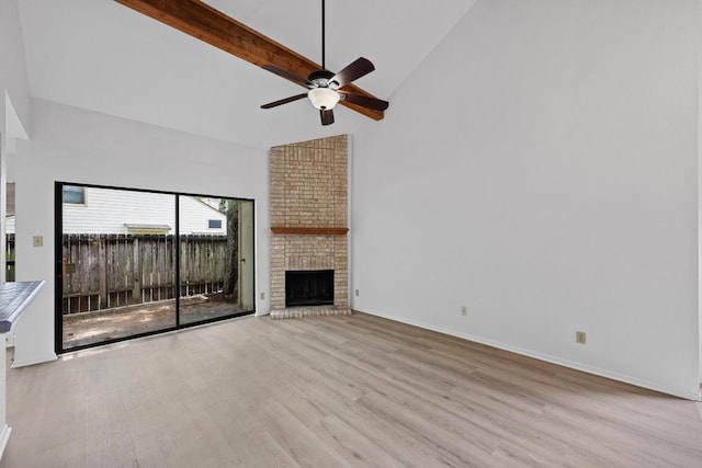 3801 Menchaca Rd Unit 6, Austin, TX 78704 - unfurnished living room with high vaulted ceiling, wood finished floors, ceiling fan, beamed ceiling, and a fireplace