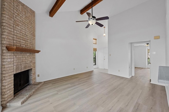 3801 Menchaca Rd Unit 6, Austin, TX 78704 - unfurnished living room with ceiling fan, high vaulted ceiling, a fireplace, beamed ceiling, and wood finished floors