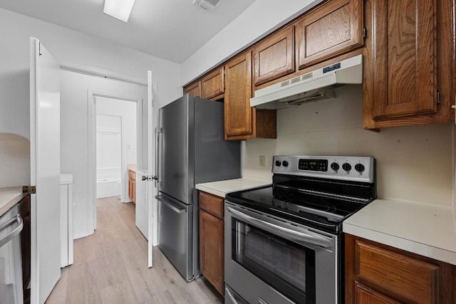 3801 Menchaca Rd Unit 6, Austin, TX 78704 - kitchen with appliances with stainless steel finishes, under cabinet range hood, light wood-style floors, brown cabinetry, and light countertops