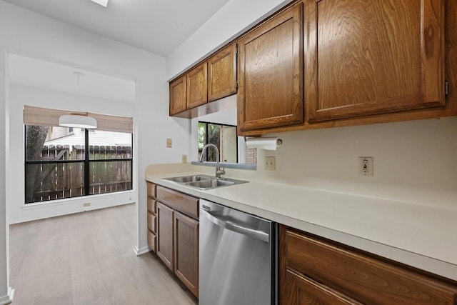 3801 Menchaca Rd Unit 6, Austin, TX 78704 - kitchen featuring dishwasher, light countertops, brown cabinetry, light wood-style flooring, and hanging light fixtures