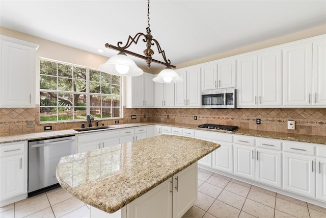9527 Indigo Brush Dr, Austin, TX 78726 - kitchen with appliances with stainless steel finishes, light tile patterned floors, tasteful backsplash, a kitchen island, and white cabinets
