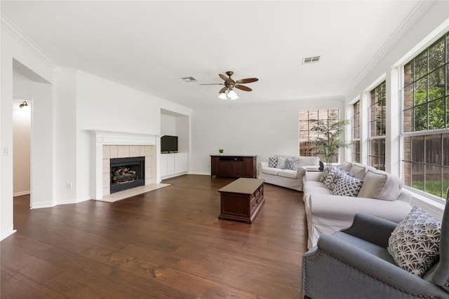 9527 Indigo Brush Dr, Austin, TX 78726 - living room featuring healthy amount of natural light, a ceiling fan, dark wood-type flooring, ornamental molding, and a fireplace