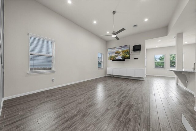 7808 Glover Dr, Austin, TX 78744 - unfurnished living room featuring ceiling fan, dark wood-style floors, recessed lighting, and a towering ceiling