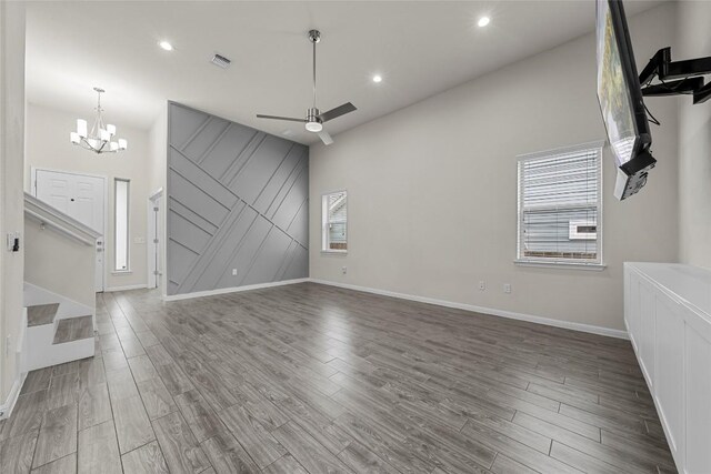 7808 Glover Dr, Austin, TX 78744 - unfurnished living room with wood finished floors, a ceiling fan, a chandelier, recessed lighting, and healthy amount of natural light