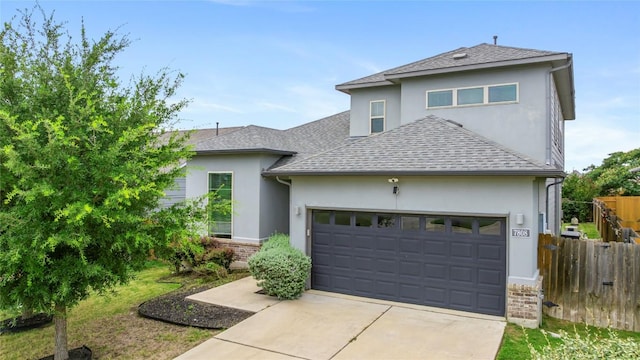 7808 Glover Dr, Austin, TX 78744 - view of front of house with stucco siding, a garage, a shingled roof, and concrete driveway
