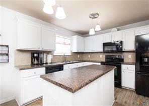 5516 Birmingham Dr, Killeen, TX 76542 - kitchen with black appliances, dark countertops, white cabinetry, and a center island