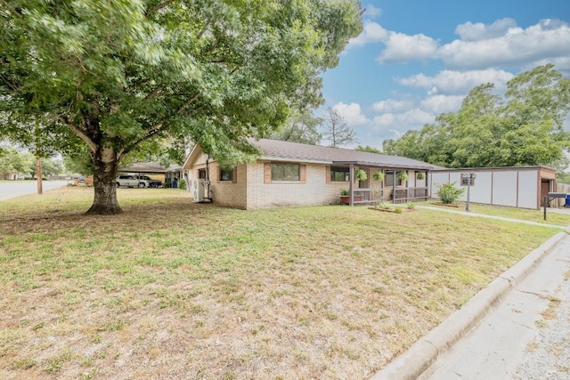 705 Dunning St, Gonzales, TX 78629 - ranch-style home with a porch, a front yard, and brick siding