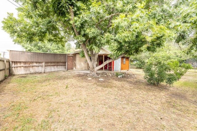 705 Dunning St, Gonzales, TX 78629 - fenced backyard featuring a storage unit