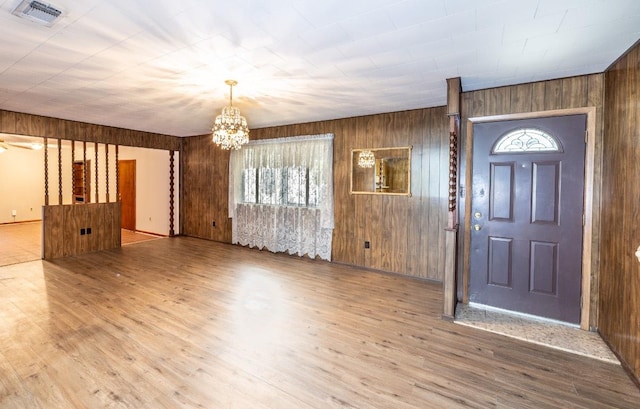 705 Dunning St, Gonzales, TX 78629 - foyer with a chandelier, wood walls, and wood finished floors