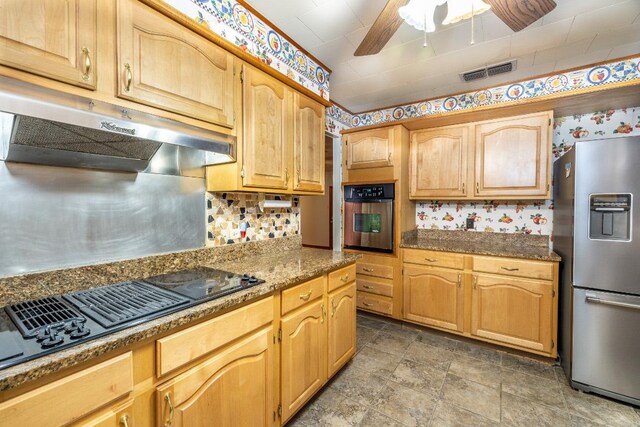 705 Dunning St, Gonzales, TX 78629 - kitchen featuring stainless steel appliances, exhaust hood, a ceiling fan, stone finish flooring, and decorative backsplash