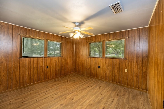 705 Dunning St, Gonzales, TX 78629 - spare room with healthy amount of natural light, ceiling fan, wood finished floors, and wooden walls