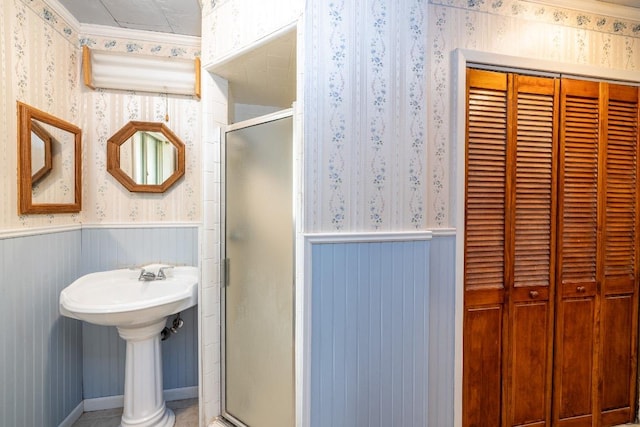 705 Dunning St, Gonzales, TX 78629 - full bathroom featuring wallpapered walls, a closet, a wainscoted wall, and a stall shower