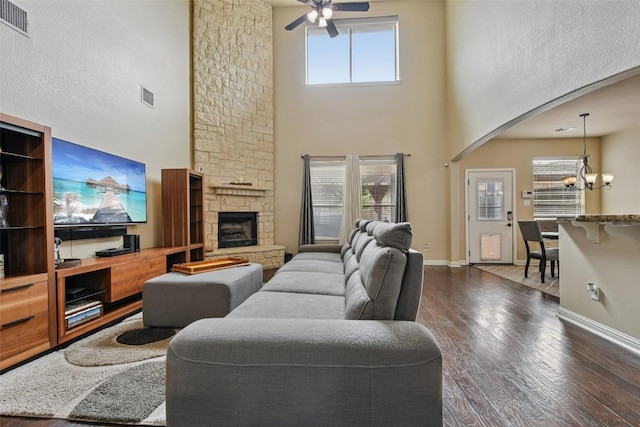3713 Glastonbury Trl, Pflugerville, TX 78660 - living room featuring arched walkways, a towering ceiling, ceiling fan, a chandelier, and dark wood-style floors