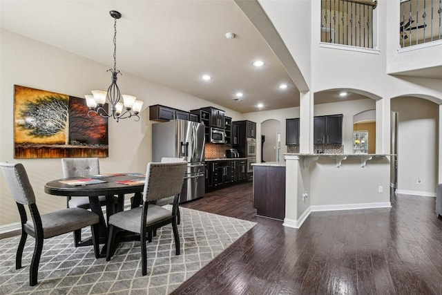 3713 Glastonbury Trl, Pflugerville, TX 78660 - dining room with arched walkways, a chandelier, dark wood-style floors, and recessed lighting
