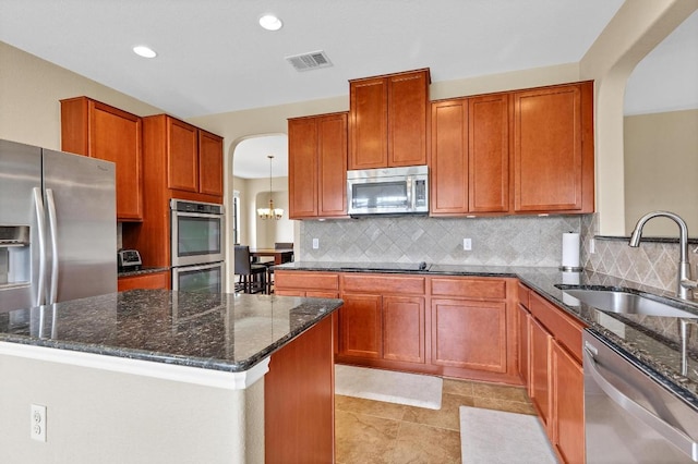 301 Wye Oak St, Austin, TX 78748 - kitchen with appliances with stainless steel finishes, arched walkways, dark stone countertops, backsplash, and recessed lighting