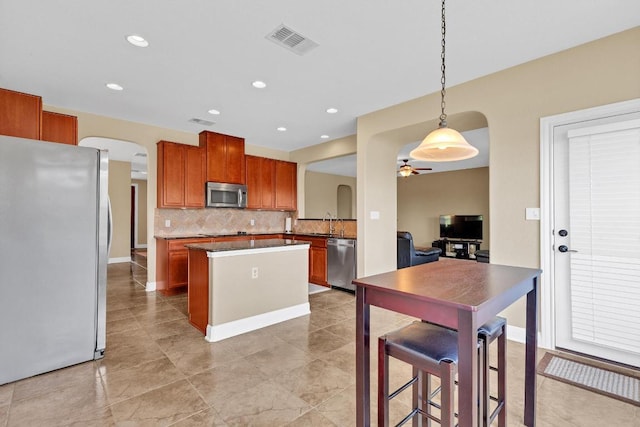 301 Wye Oak St, Austin, TX 78748 - kitchen featuring stainless steel appliances, arched walkways, ceiling fan, tasteful backsplash, and recessed lighting