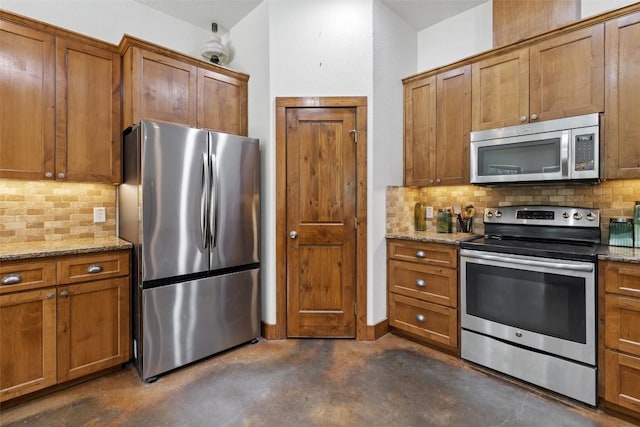 267 Corral Rd, Smithville, TX 78957 - kitchen with appliances with stainless steel finishes, concrete flooring, brown cabinetry, tasteful backsplash, and light stone counters