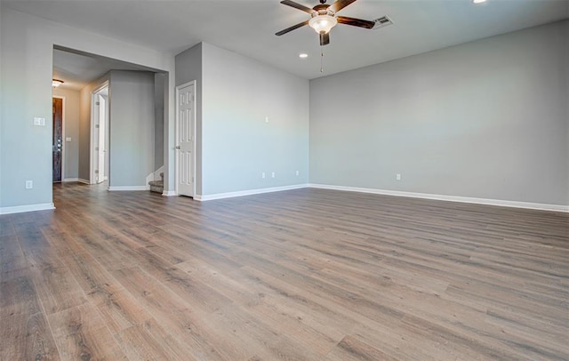 2836 Garnet Ridge Dr, Leander, TX 78641 - empty room with a ceiling fan, wood finished floors, recessed lighting, and stairs