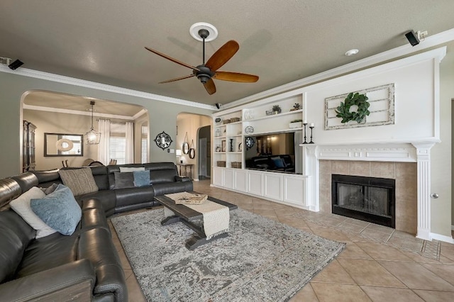 19709 Vilamoura St, Pflugerville, TX 78660 - living room featuring arched walkways, ceiling fan, light tile patterned floors, and ornamental molding