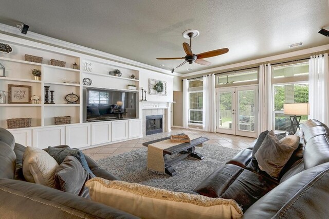 19709 Vilamoura St, Pflugerville, TX 78660 - living room featuring light tile patterned floors, ceiling fan, ornamental molding, a textured ceiling, and built in features