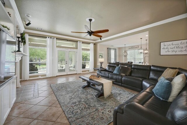 19709 Vilamoura St, Pflugerville, TX 78660 - tiled living area with ceiling fan, crown molding, french doors, and a chandelier