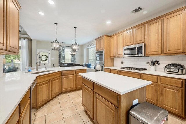 19709 Vilamoura St, Pflugerville, TX 78660 - kitchen with appliances with stainless steel finishes, tasteful backsplash, healthy amount of natural light, light countertops, and recessed lighting