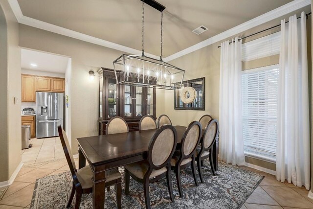 19709 Vilamoura St, Pflugerville, TX 78660 - dining area featuring light tile patterned floors, a chandelier, and ornamental molding