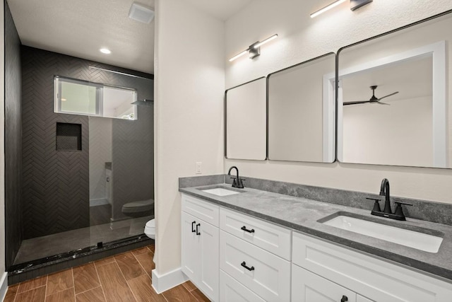 147 Kahana Ln, Bastrop, TX 78602 - full bathroom with a ceiling fan, double vanity, and tiled shower