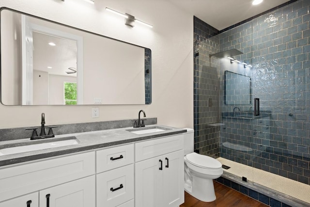 147 Kahana Ln, Bastrop, TX 78602 - full bathroom featuring a stall shower, wood finished floors, double vanity, and recessed lighting