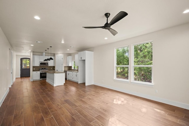 147 Kahana Ln, Bastrop, TX 78602 - unfurnished living room with ceiling fan, recessed lighting, and wood finished floors