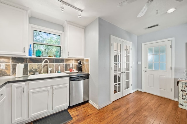 1807 Cullen Ave, Austin, TX 78757 - kitchen with stainless steel dishwasher, french doors, light wood-style flooring, tasteful backsplash, and white cabinets