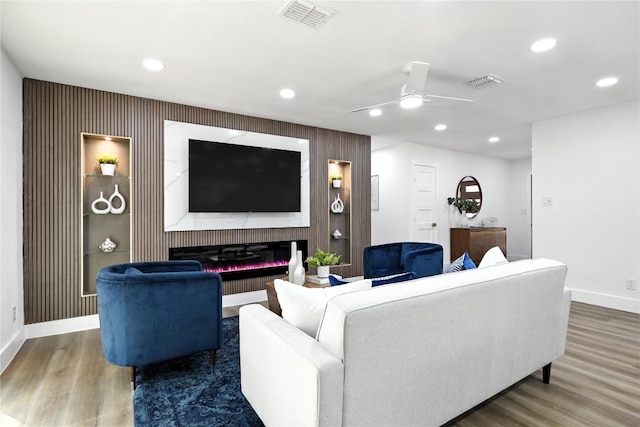 2400 Burly Oak Dr, Austin, TX 78745 - living room featuring ceiling fan, recessed lighting, wood finished floors, an accent wall, and a glass covered fireplace