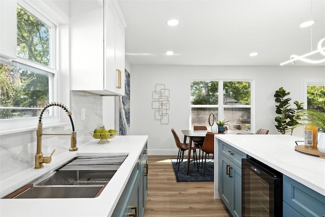 2400 Burly Oak Dr, Austin, TX 78745 - kitchen featuring wine cooler, recessed lighting, white cabinetry, light wood-style flooring, and light countertops