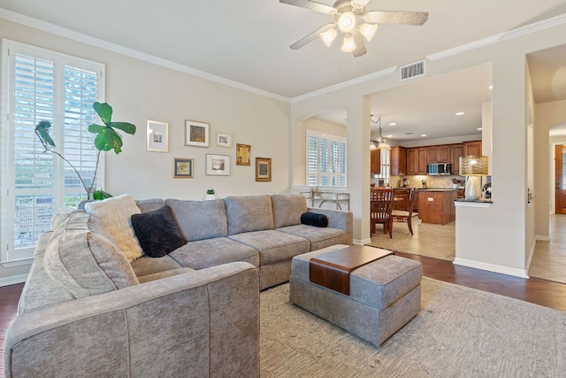 2634 Plantation Dr, Round Rock, TX 78681 - living area featuring plenty of natural light, arched walkways, wood finished floors, a ceiling fan, and ornamental molding
