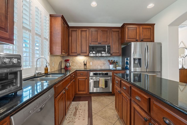 2634 Plantation Dr, Round Rock, TX 78681 - kitchen with appliances with stainless steel finishes, recessed lighting, backsplash, dark stone counters, and light tile patterned floors