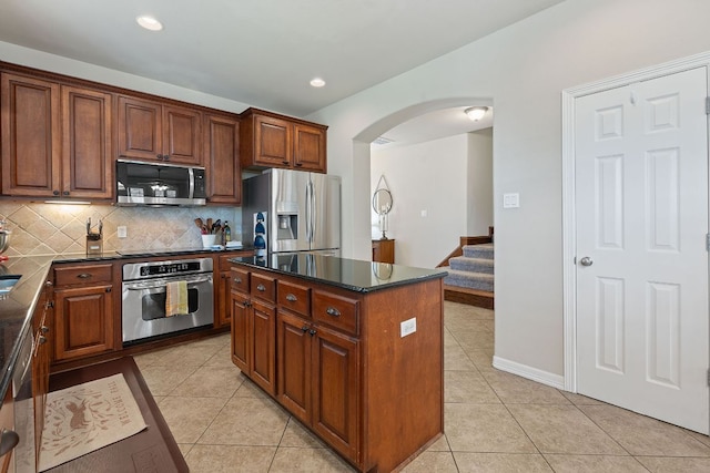 2634 Plantation Dr, Round Rock, TX 78681 - kitchen with appliances with stainless steel finishes, arched walkways, light tile patterned floors, decorative backsplash, and recessed lighting