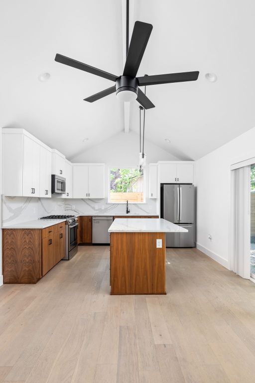 2813 Prado Unit 2, Austin, TX 78702 - kitchen with stainless steel appliances, light wood-style flooring, a center island, a ceiling fan, and light countertops