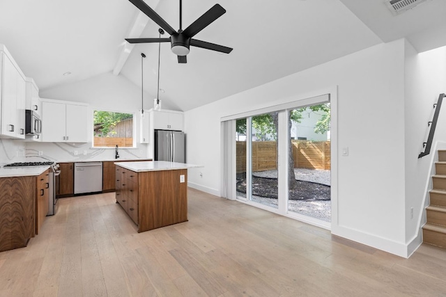 2813 Prado Unit 2, Austin, TX 78702 - kitchen with stainless steel appliances, a ceiling fan, a center island, white cabinetry, and light wood finished floors