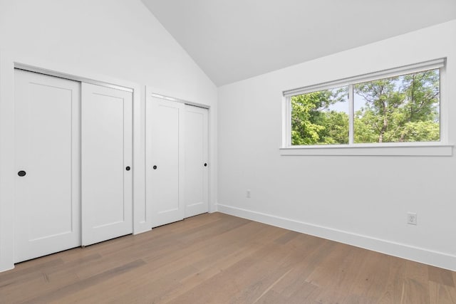 2813 Prado Unit 2, Austin, TX 78702 - unfurnished bedroom featuring two closets, wood finished floors, and lofted ceiling