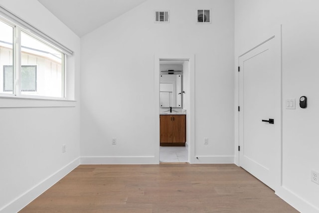 2813 Prado Unit 2, Austin, TX 78702 - unfurnished bedroom featuring lofted ceiling, light wood-style flooring, and connected bathroom