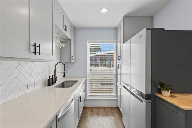 3812 Southway Dr Unit 103, Austin, TX 78704 - kitchen featuring freestanding refrigerator, dishwasher, backsplash, wood finished floors, and gray cabinetry