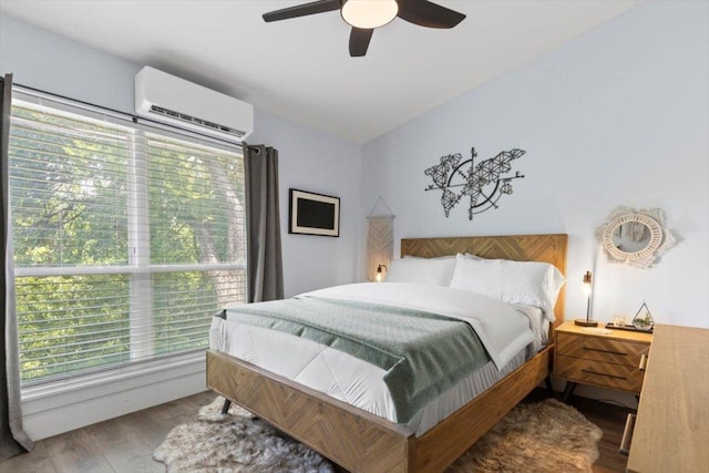 3812 Southway Dr Unit 103, Austin, TX 78704 - bedroom featuring a wall unit AC, multiple windows, wood finished floors, and a ceiling fan