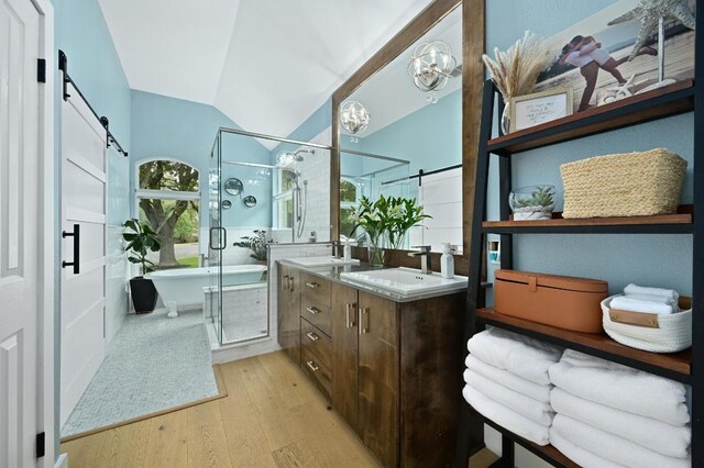 3703 Runnels Ct, Austin, TX 78732 - bathroom featuring wood finished floors, double vanity, a soaking tub, a stall shower, and lofted ceiling