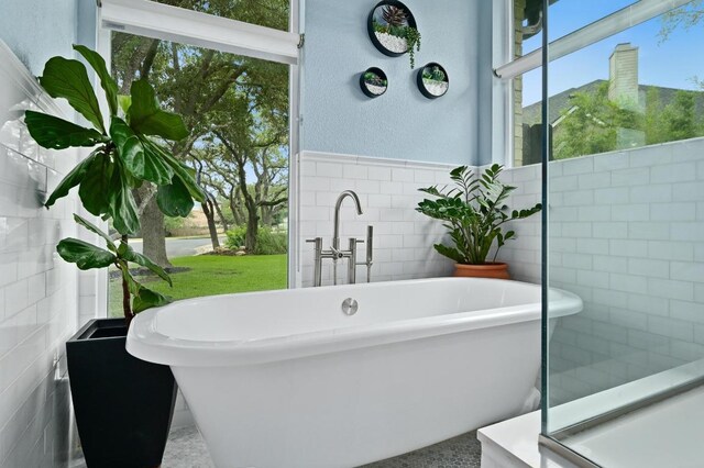 3703 Runnels Ct, Austin, TX 78732 - full bath featuring tile walls, a freestanding tub, and a textured wall