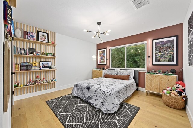 3703 Runnels Ct, Austin, TX 78732 - bedroom with light wood finished floors and a chandelier